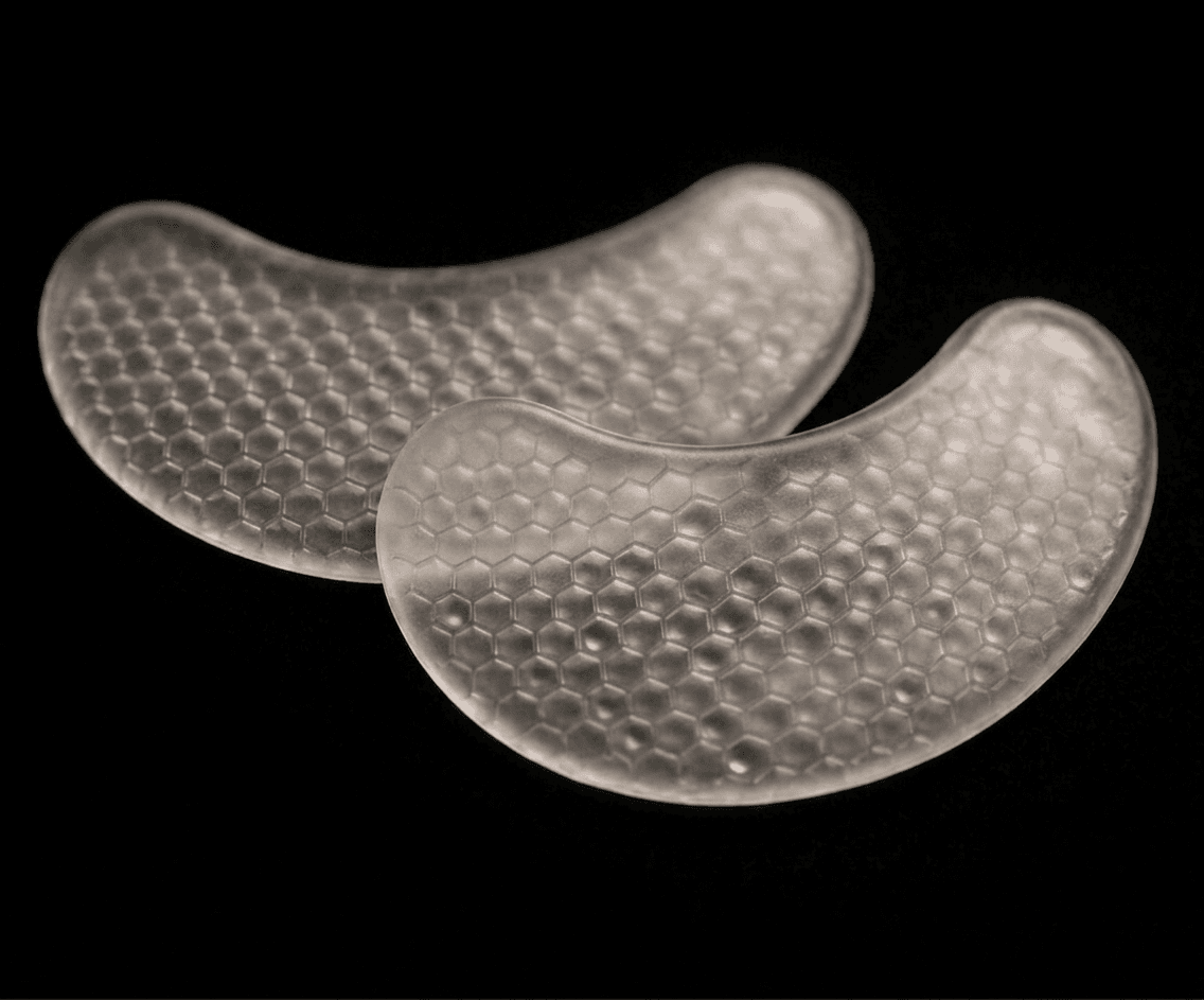 A pair of Identité crescent patches photographed in profile, the curved silicone reservoir shape visible